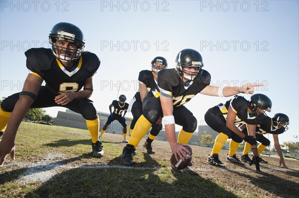 Football players crouching on football field