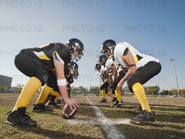 Football players crouching on football field