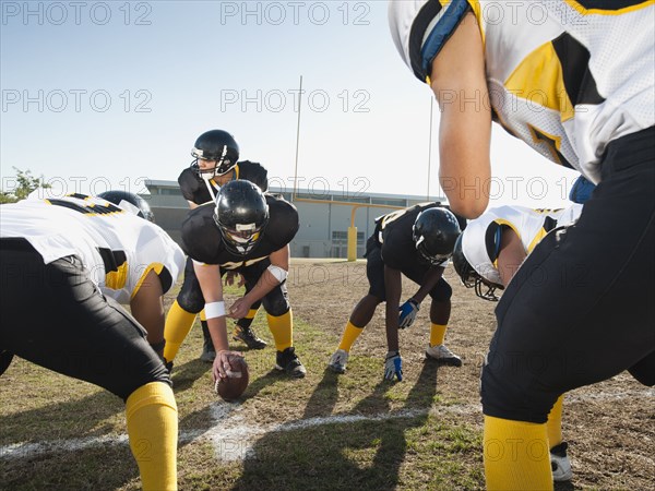 Football players crouching on football field