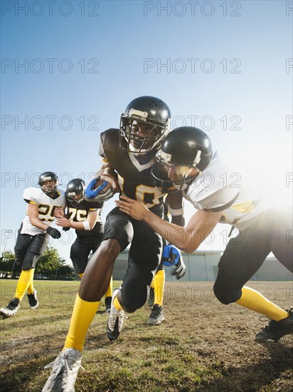 Football player tackling player on football field