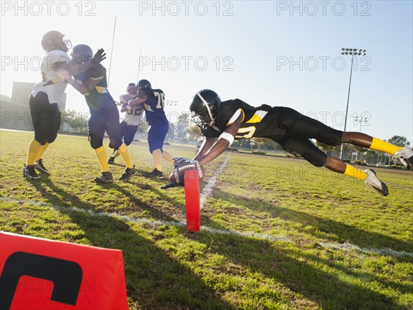 Football player scoring goal on football field