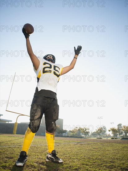 Hispanic football player cheering on football field