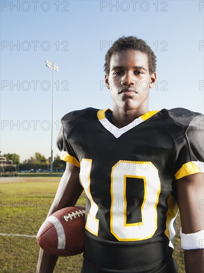 Black football player holding football