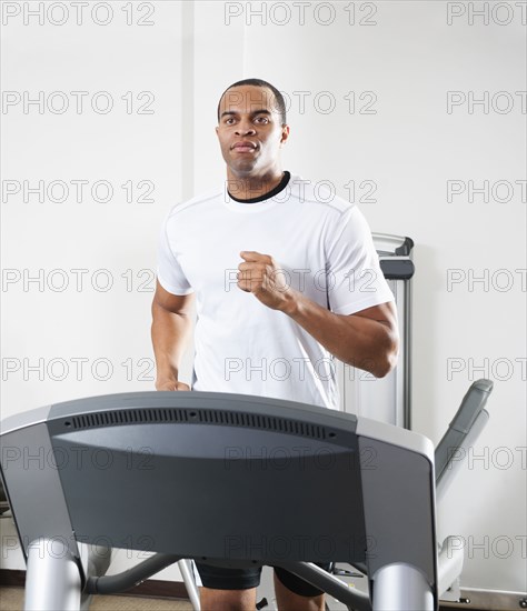 Mixed race man running on treadmill