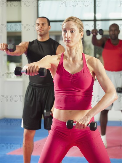 People exercising with hand weights in health club