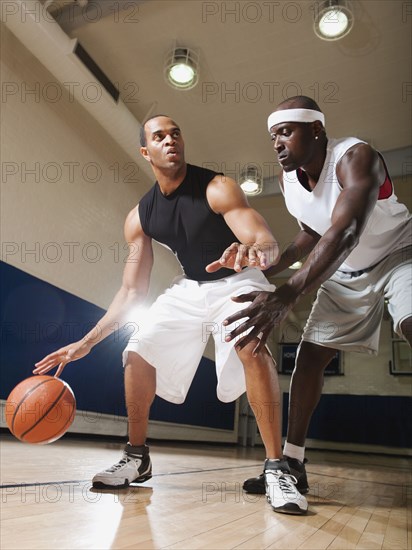 Men playing basketball on basketball court