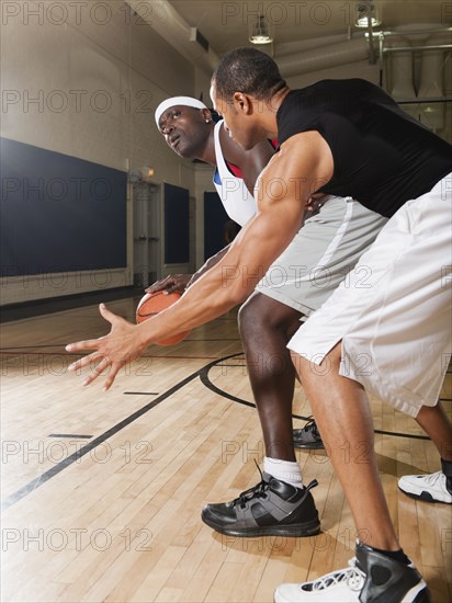 Men playing basketball on basketball court