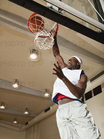 Black man shooting baskets on basketball court