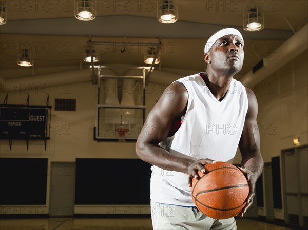 Black man shooting basketball on basketball court