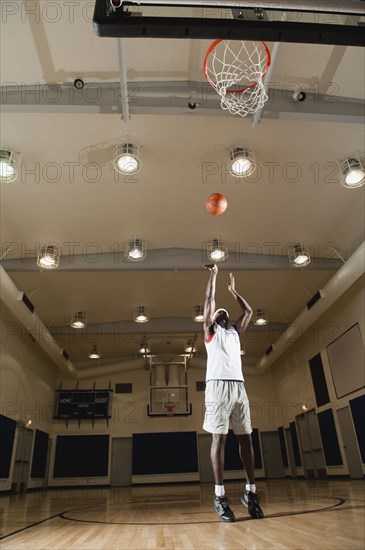 Black man shooting basketball on basketball court