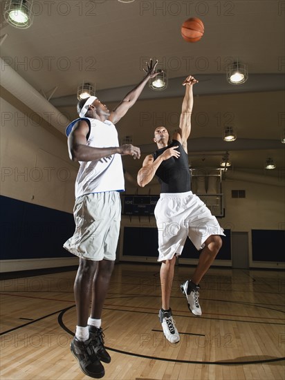 Men playing basketball on basketball court