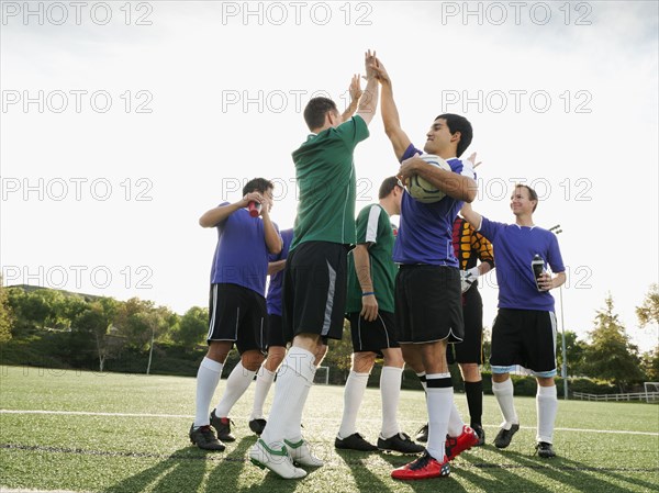 Soccer players cheering on soccer field