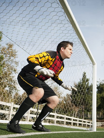 Mixed race goalkeeper protecting goal