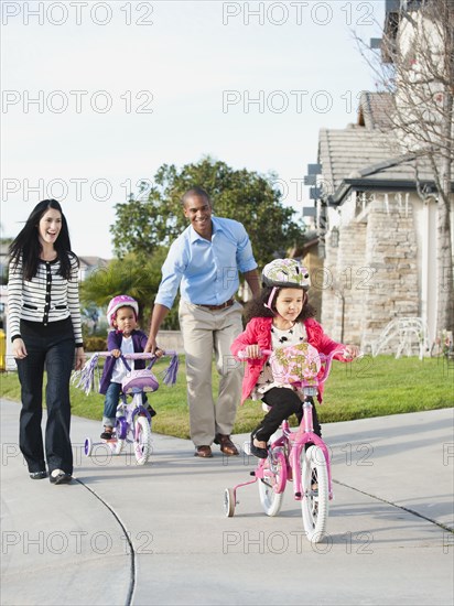 Parents watching children ride bicycles