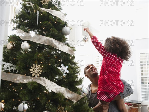 Father and daughter decorating Christmas tree