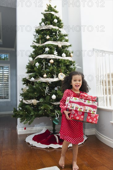 Mixed race girl holding Christmas gift