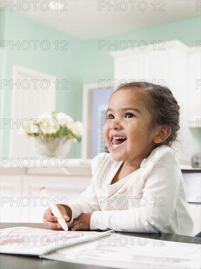 Mixed race girl drawing in notebook