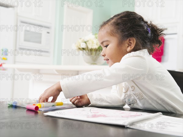 Mixed race girl drawing in notebook