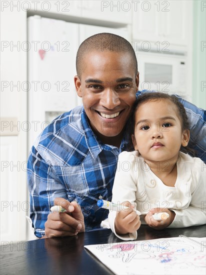 Father watching his daughter drawing