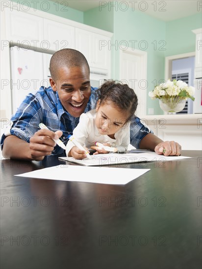 Father watching his daughter drawing