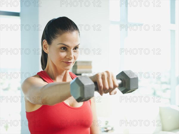 Mixed race woman exercising with dumbbells