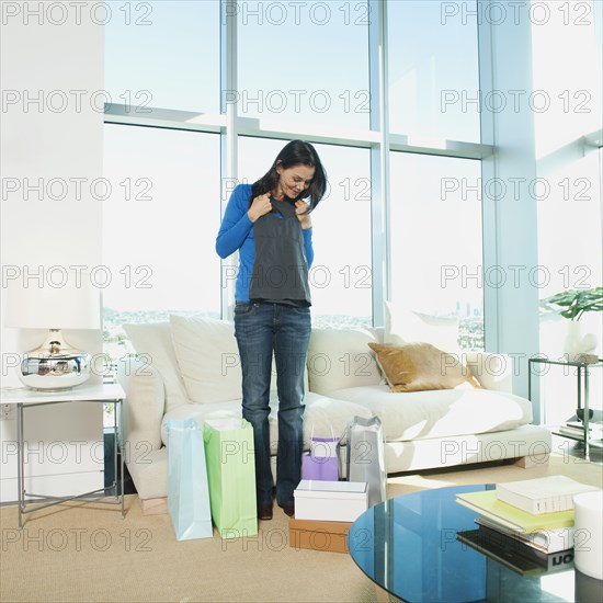 Mixed race woman looking at clothing in living room