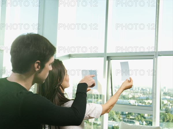 Couple looking at color swatches near window