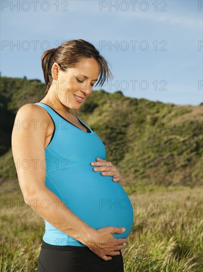 Pregnant Hispanic woman caressing her stomach