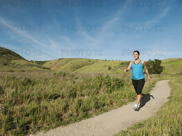 Pregnant Hispanic woman running in remote area