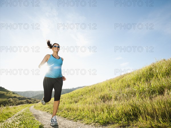 Pregnant Hispanic woman running in remote area