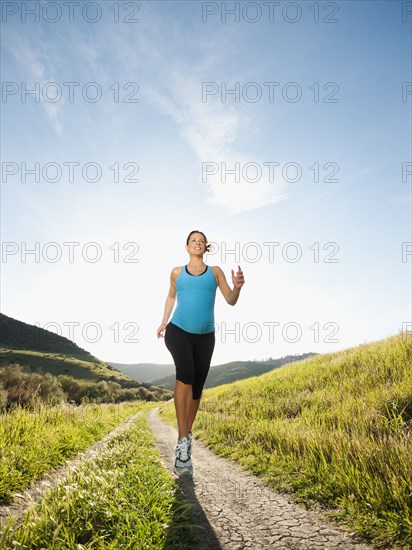 Pregnant Hispanic woman running in remote area