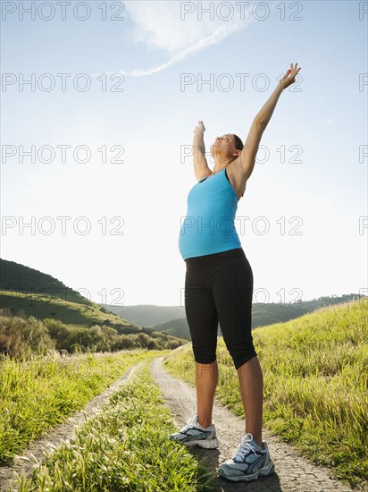 Pregnant Hispanic woman exercising in remote area