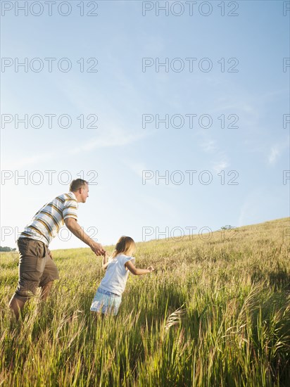 Father and daughter walking up hill together