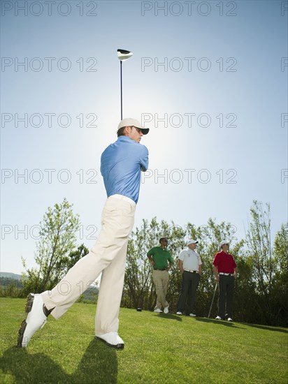 Men playing golf together on golf course