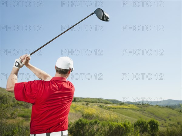 Caucasian golfer swinging golf club