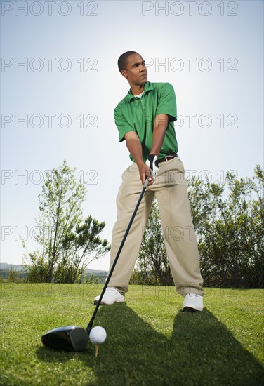 Black golfer preparing to swing golf club