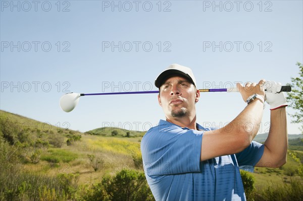 Caucasian golfer swinging golf club