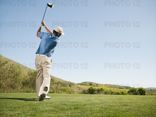 Caucasian golfer swinging golf club