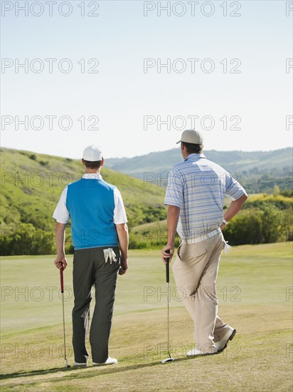 Caucasian men playing golf together on golf course