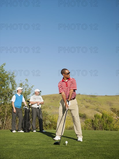 Men playing golf together on golf course