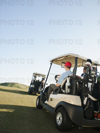 Men driving golf carts on golf course
