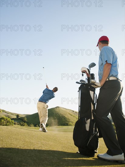 Men playing golf on golf course