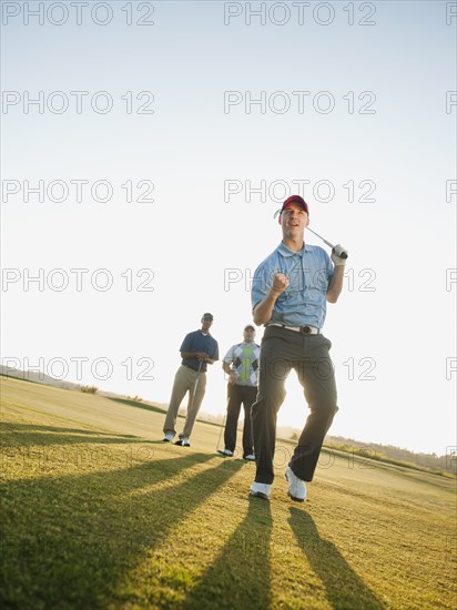 Friends watching golfer cheering