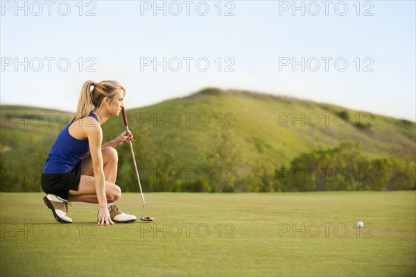 Caucasian woman checking ground on golf course