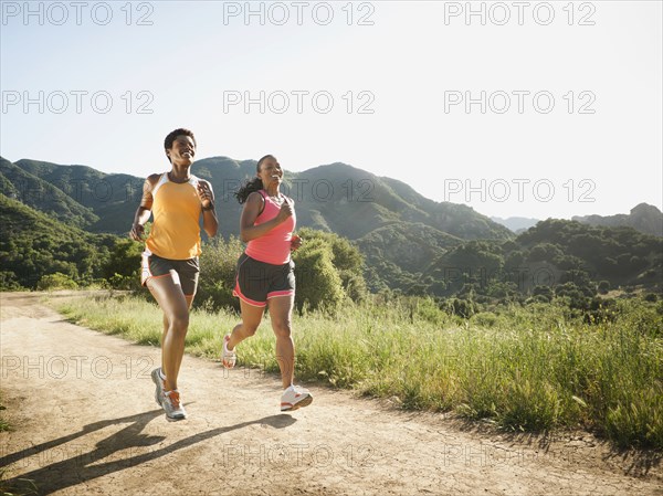 Women running together on remote trail