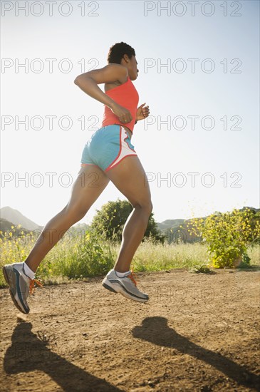 Mixed race woman running on remote trail