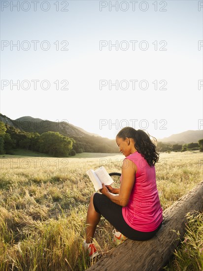 Black woman reading book in remote area