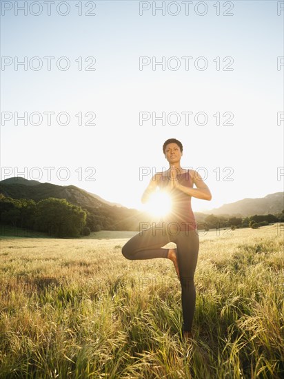 Mixed race woman practicing yoga in remote area