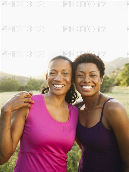 Smiling friends hugging outdoors