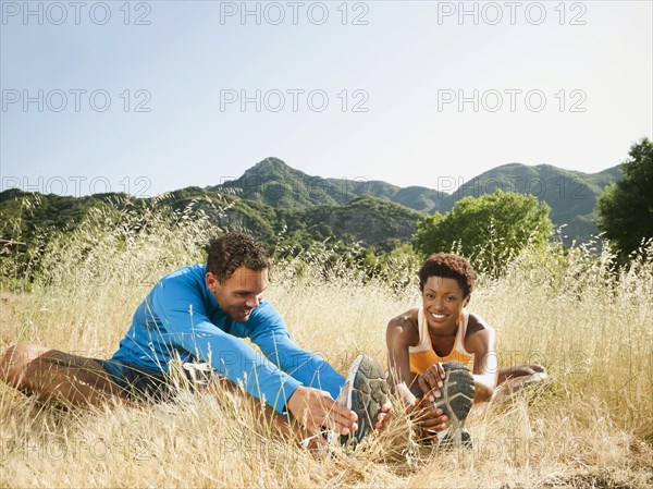 Couple stretching together outdoors before exercise